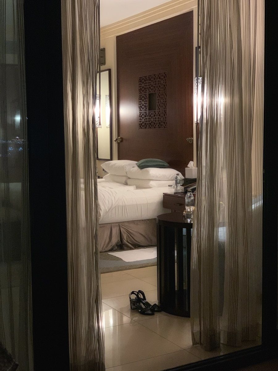 white bed linen near brown wooden door