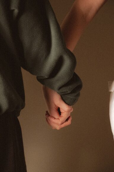 Two people holding hands closely