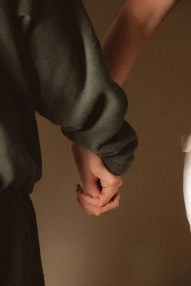 Two people holding hands closely