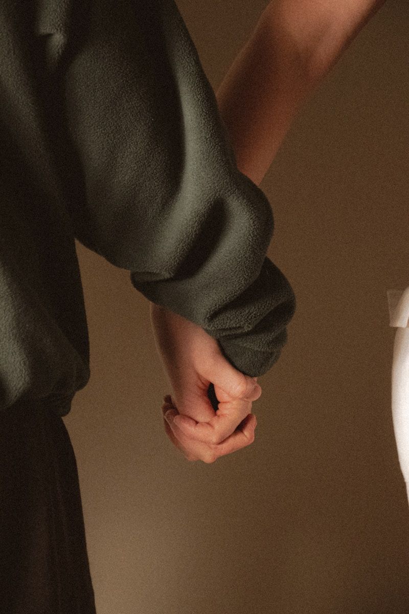 Two people holding hands closely