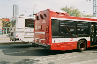 A red and white bus driving down a street