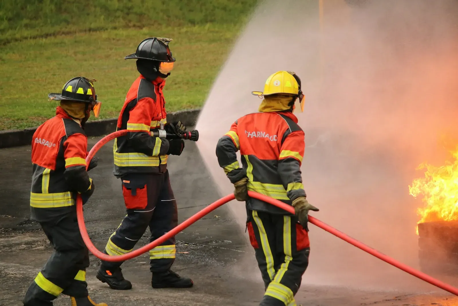 Firefighters extinguish a blaze with water hoses